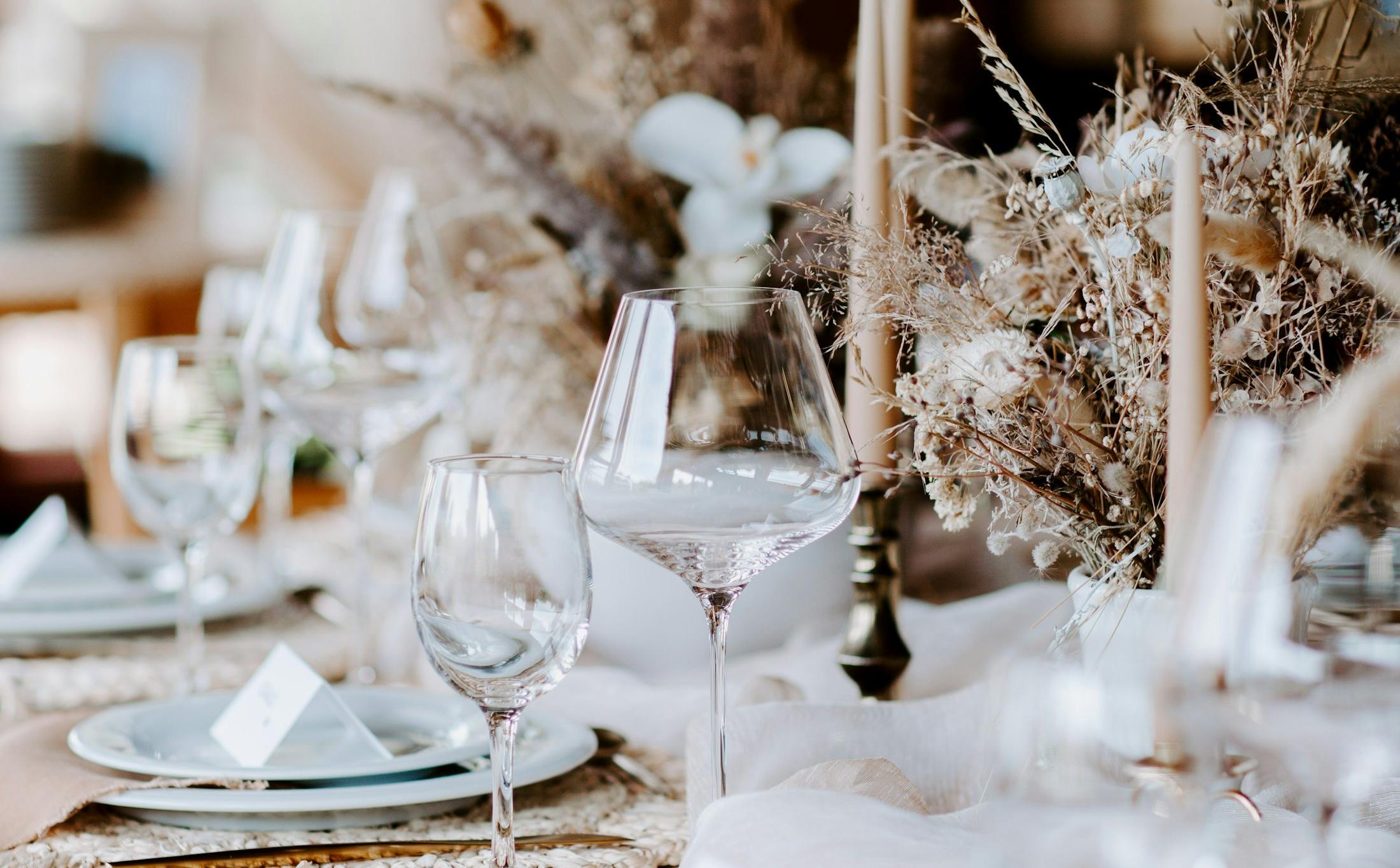 Candlelit wedding reception table with dried florals, taper candles and crystal glassware