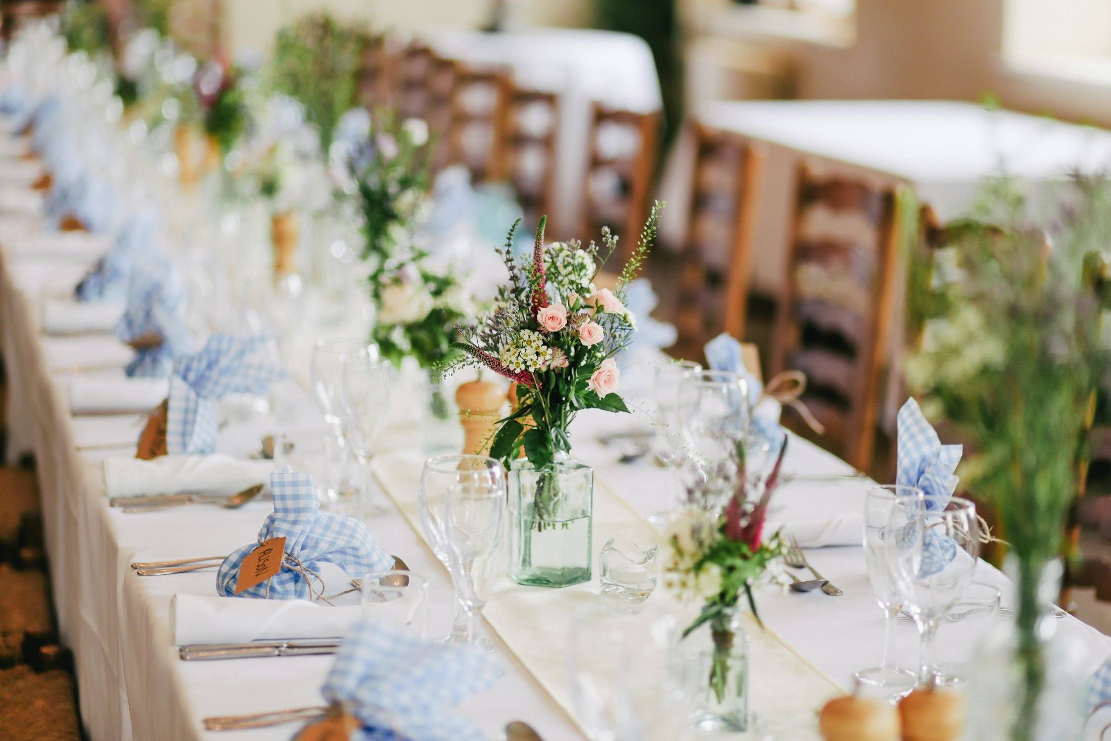 Long reception table with dusty-blue napkins and garden florals